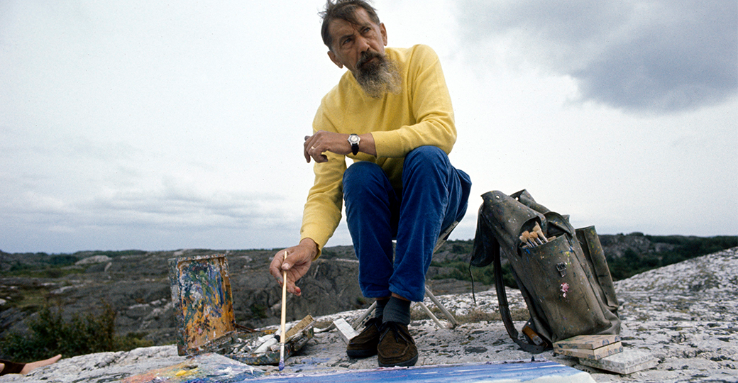 Foto av Inge Schiöler som sitter och målar på ett berg.