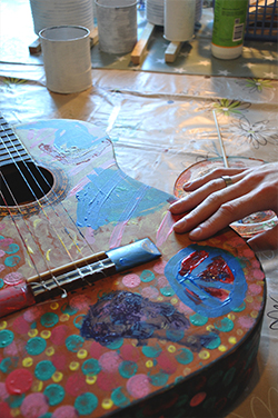 Gitarr som är målad i glada färger.