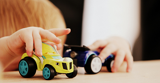 Foto på ett barn som leker med bilar.