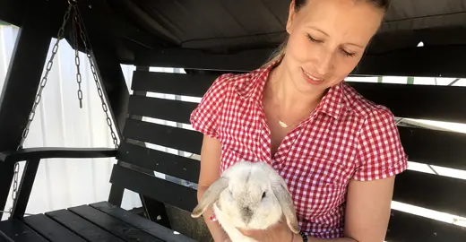 Undersköterska sitter med en kanin i famnen.